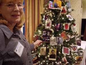 Carol placing a picture of her Dad on tree